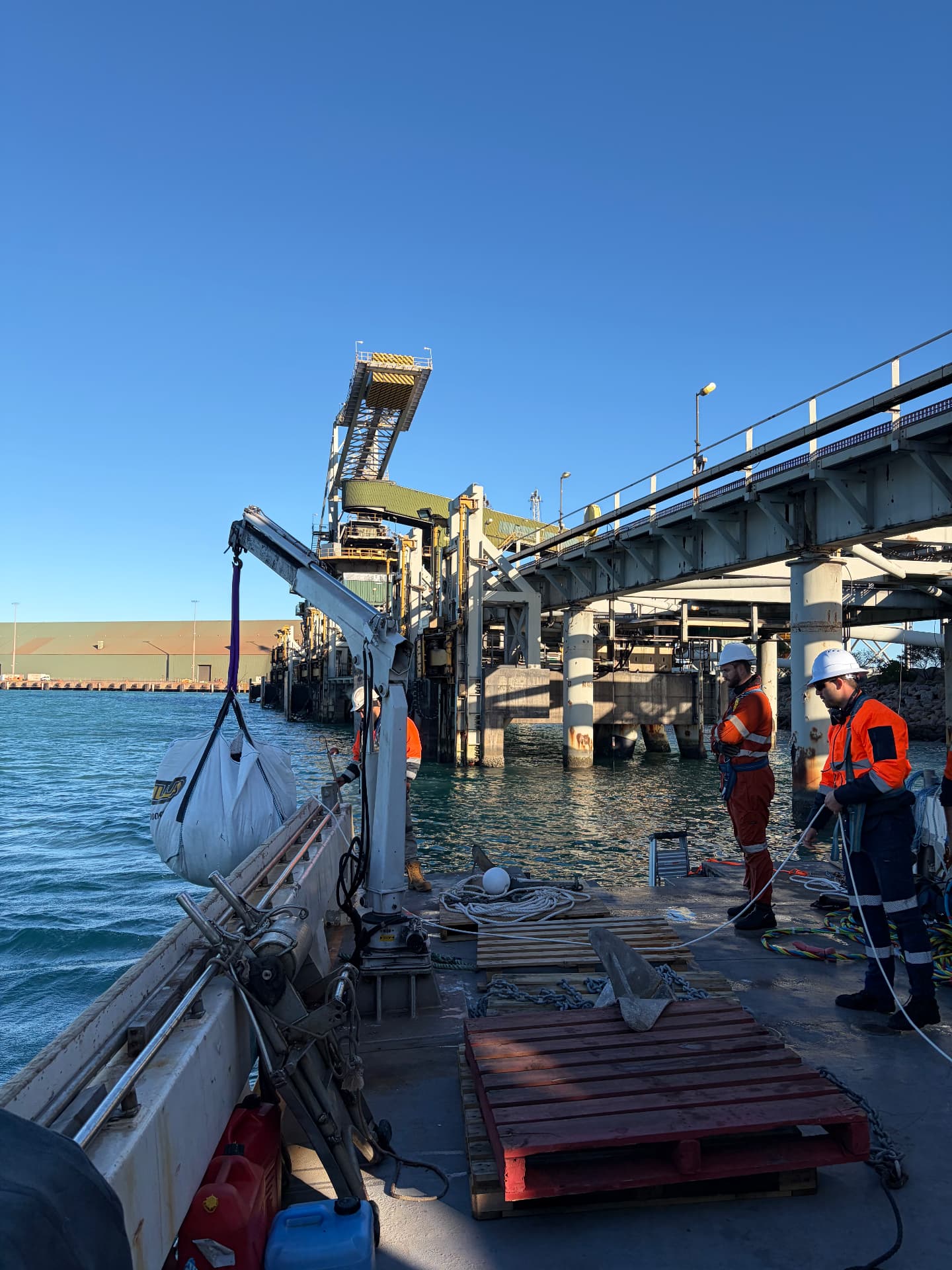 Deck crane lifting a bulk bag during wharf works