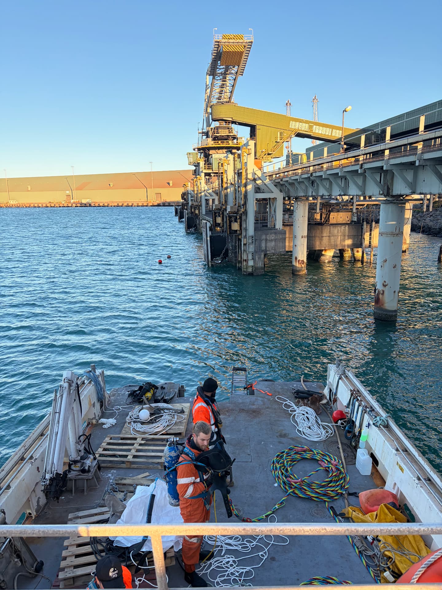 Dive team preparing on deck alongside a port jetty